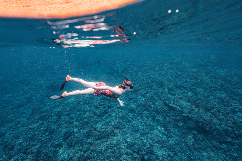 snorkeler in blue water near molokini crater