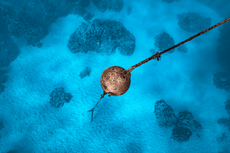 Unterwasser-Verankerungsboje und -Leine über einem sandigen Meeresboden und Korallenriffen im Molokini-Krater