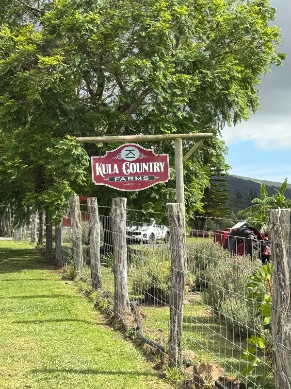 Kula Country Farms sign with wooden fence and greenery in Upcountry Maui