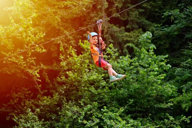 Child riding a zipline through Maui - things to do in Maui with kids