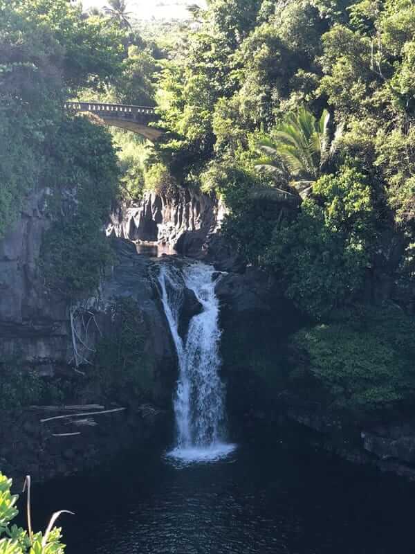 Makapipi Falls, one of the best waterfalls in Maui beneath a stone bridge surrounded by lush jungle