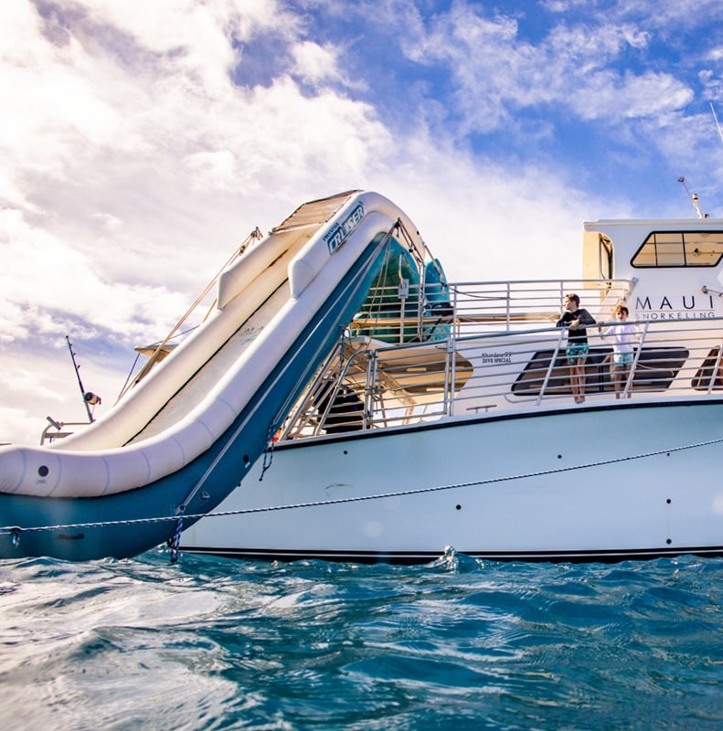 Two boys gather and enjoy time together on a boat during a Maui Snorkeling Charter Event.