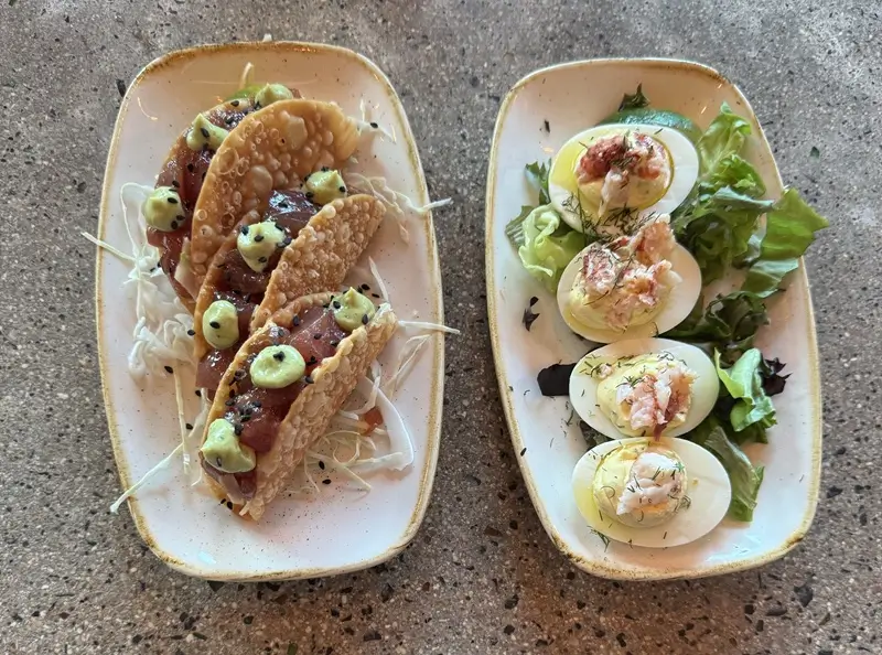 Appetizers at Monkeypod Maui including crispy tacos with ahi and deviled eggs on greens