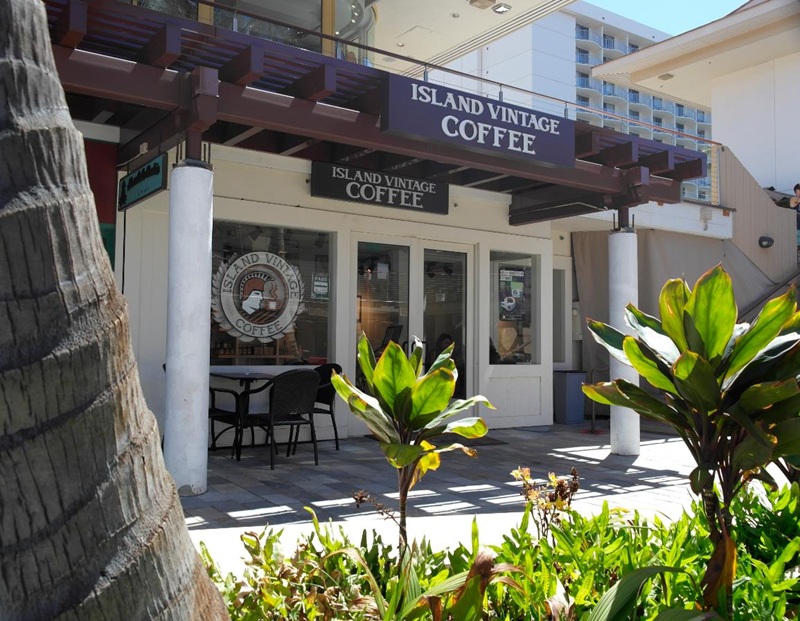 Das Café Island Vintage Coffee mit Außensitzplätzen und tropischen Pflanzen befindet sich in Whalers Village auf Maui.