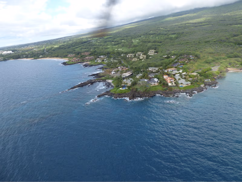 Aerial view of the rocky shoreline and blue water at Makena Landing, Maui