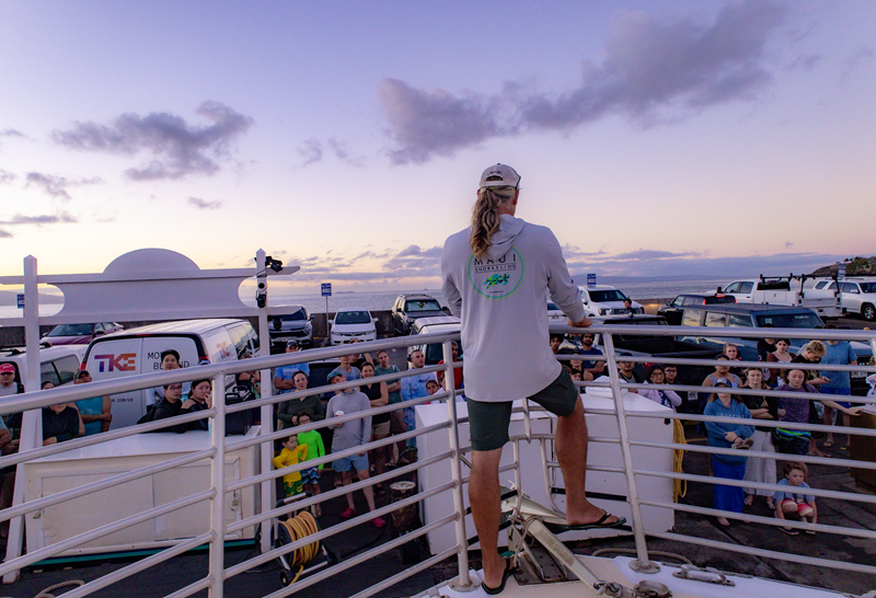 Maui Snorkeling crew member gives a boat briefing to guests gathered at the harbor before a snorkeling tour.
