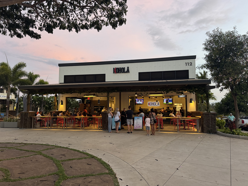 Koholā Brewery exterior, a Maui brewery with guests seated outside at sunset.