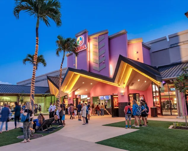 Visitors outside the Regal Maui Mall movie theater in Kahului at dusk