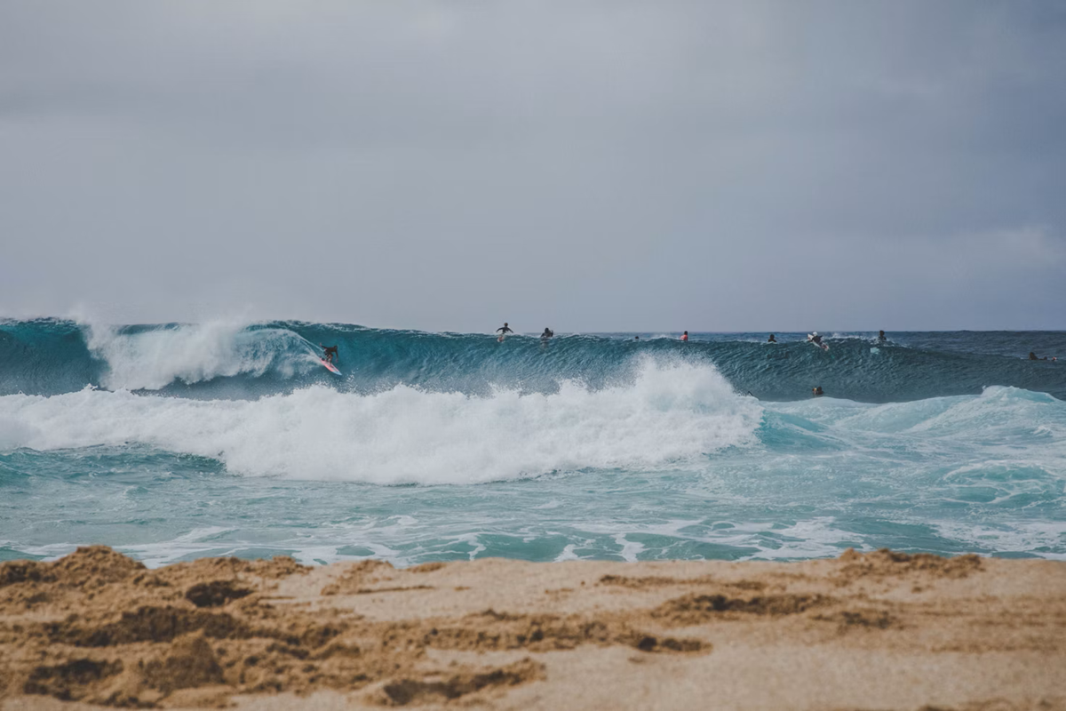 Surfer riding a breaking wave off the coast of Maui.